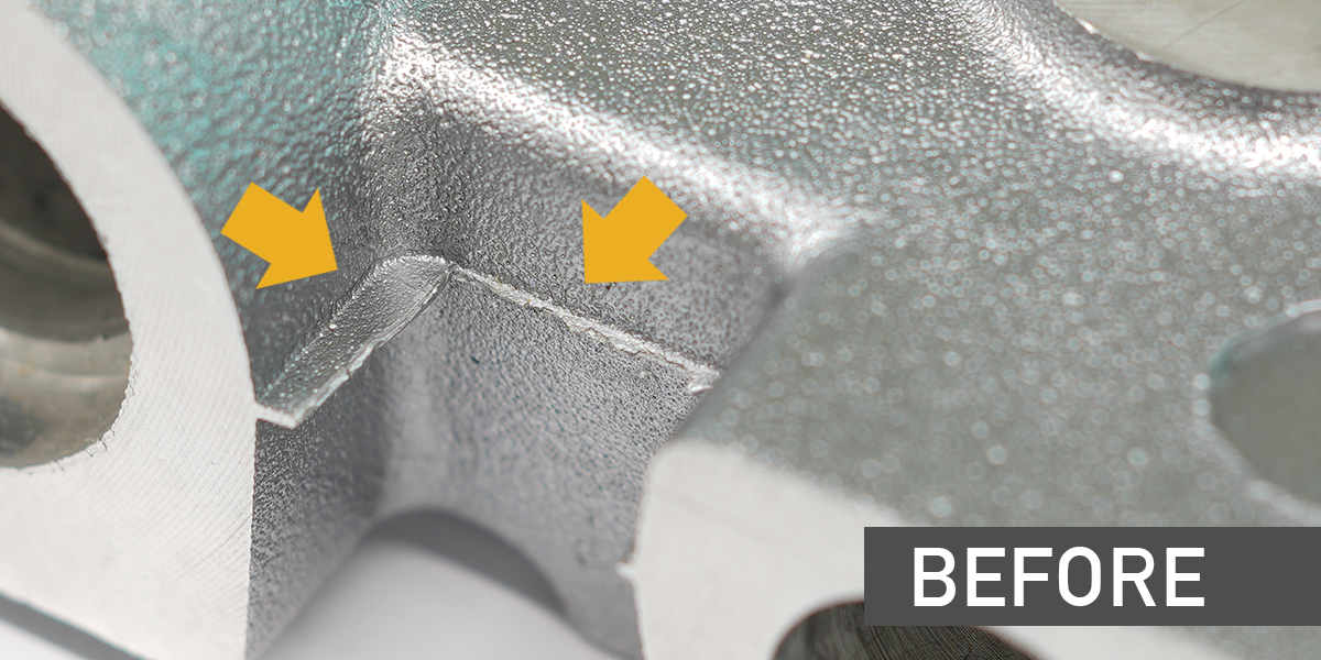 A die cast part shows metal burrs along the parting lines before deburring